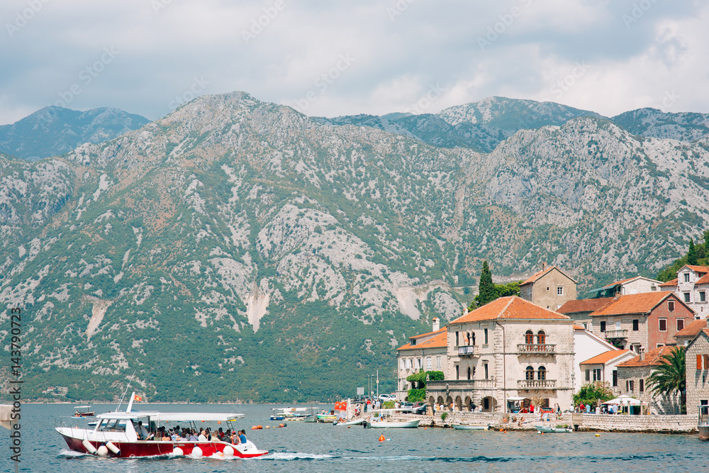 The old town of Perast on the shore of Kotor Bay, Montenegro. The ancient architecture of the Adriatic and the Balkans. Boats and yachts on the dock.
