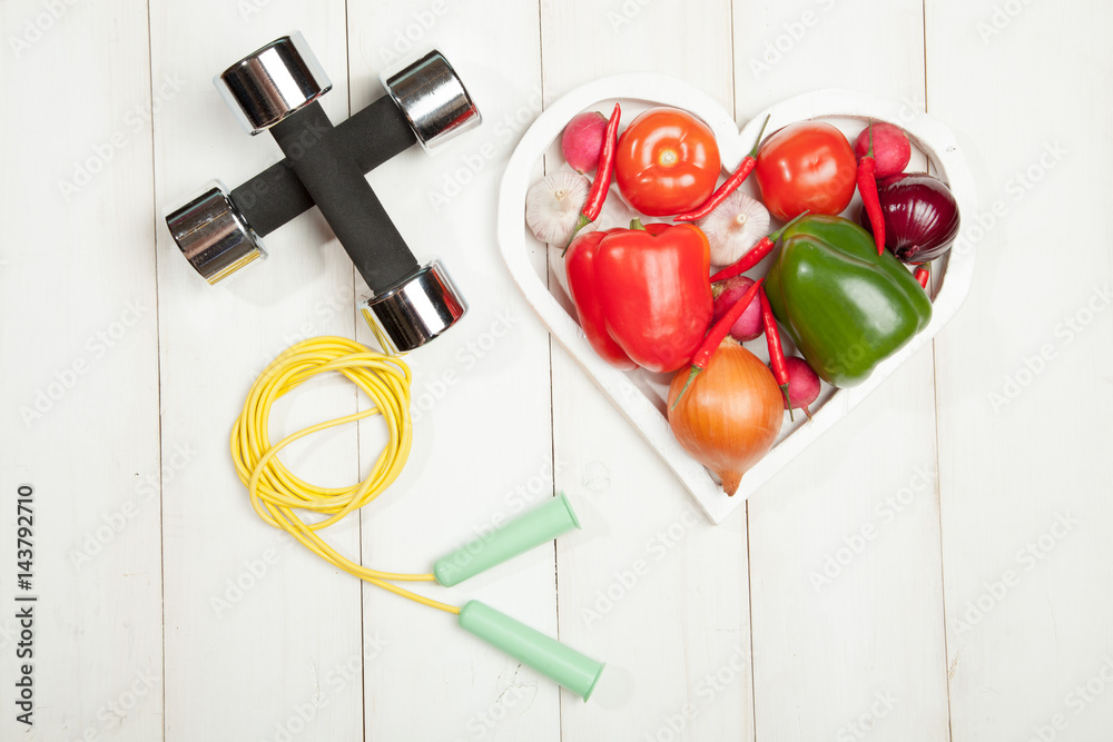 Sport and diet. Healthy lifestyle. Vegetables, dumbbells. Peppers,  tomatoes, garlic, onion radish in a heart on white background Stock Photo |  Adobe Stock