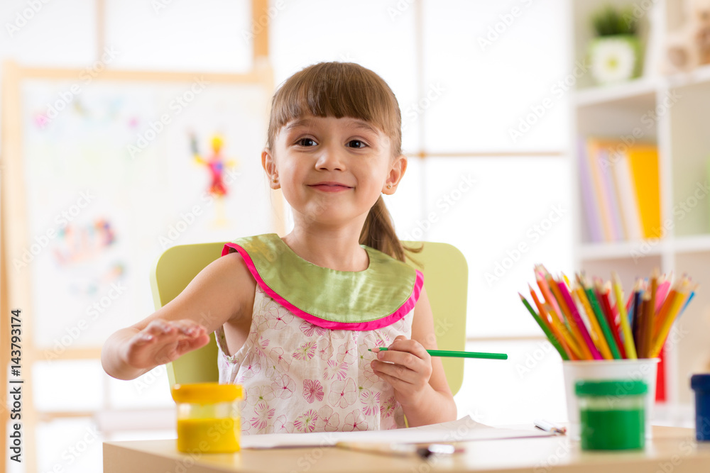 Cute preschooler child girl drawing with pencils in nursery Cute preschooler child girl drawing with pencils in nursery