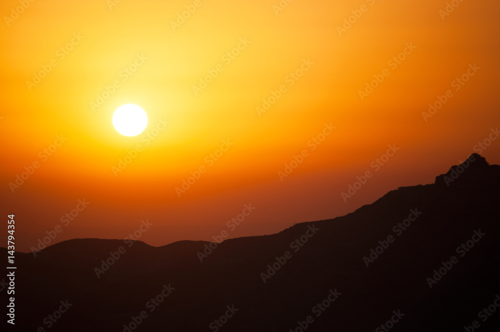 Natura e vita all'aria aperta: un tramonto infuocato sulla sagoma scura di una montagna