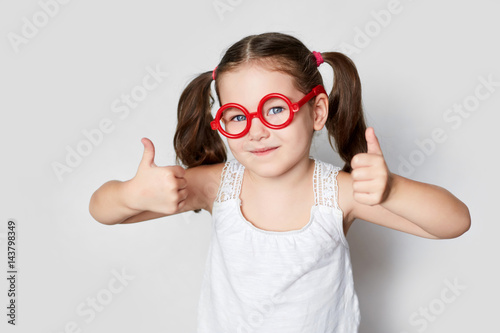 smiling little girl in red toy glasses