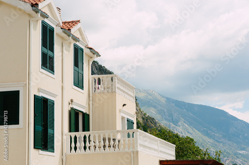 Green window shutters. The facade of houses in Montenegro. © Nadtochiy