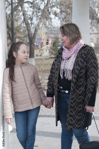 Mother with the daughter walk in the park.