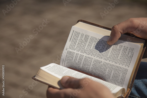 Young man holding and reading holy bible photo