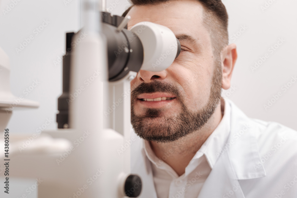 Delighted professional oculist enjoying his job Delighted professional oculist enjoying his job