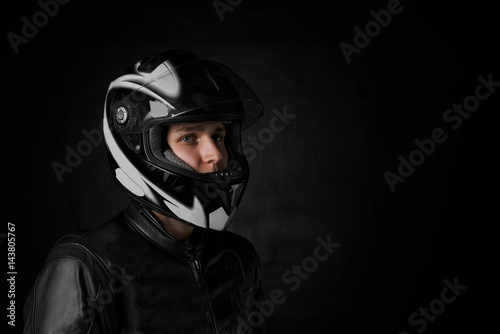 Close up side portrait of extreme man in motorcycle helmet. Copy space for advertising moto goods or promotion text. Biker drive his bike for repairing. Motorbiker concept.