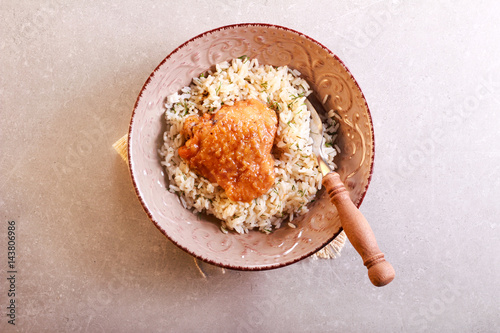 Herby rice with spicy chicken thigh in a bowl
