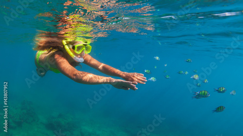 Happy family - girl in snorkeling mask dive underwater with fishes school in coral reef sea pool. Travel lifestyle, water sport outdoor adventure, swimming lessons on summer beach holidays with child. © Tropical studio