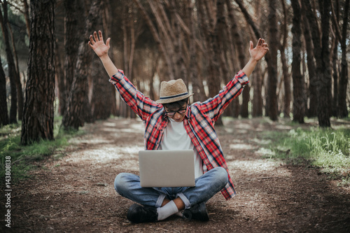 Very happy guy with a laptop in the nature