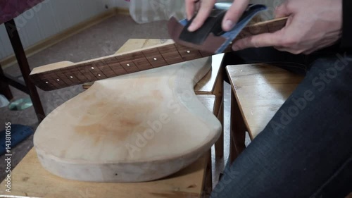 The master of repair of guitars repairs an electric guitar