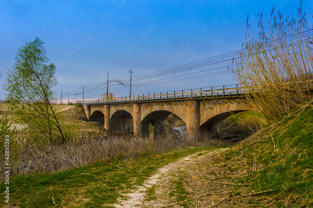 Rural Stone Road Bridge Crossing River With Beautiful Landscape, saturated photo