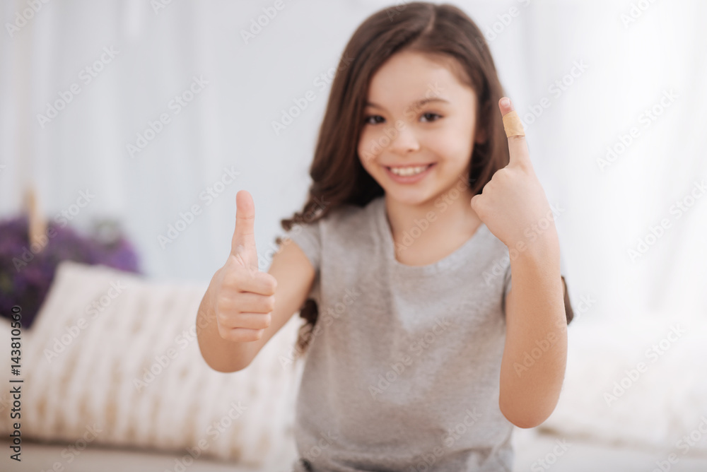 Sunny little girl demonstrating injured finger at home Sunny little girl demonstrating injured finger at home