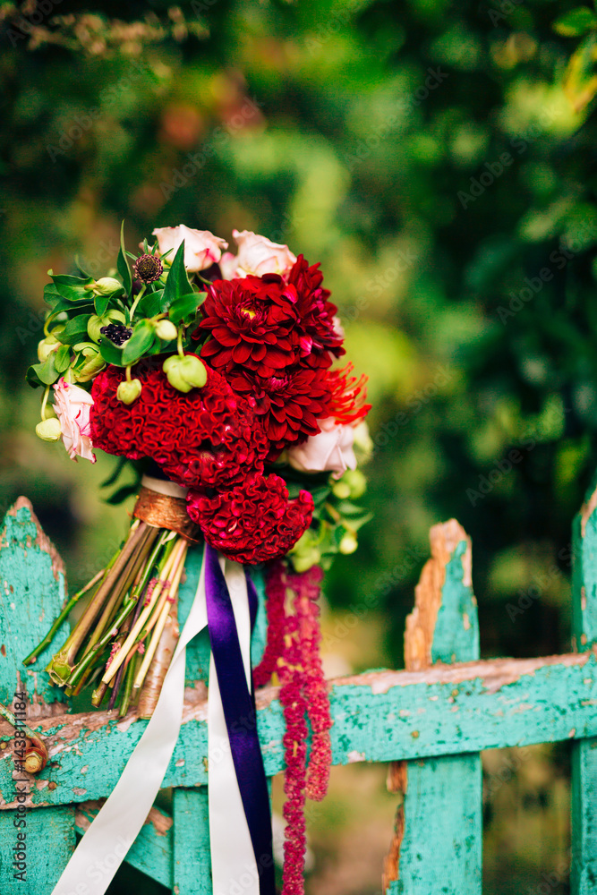 Wedding bridal bouquet of roses, celosia, Proteus on the green wooden fence. Wedding in Montenegro, Adriatic.