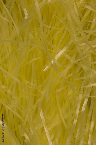 This is a photograph of Yellow shredded plastic fake Easter grass background