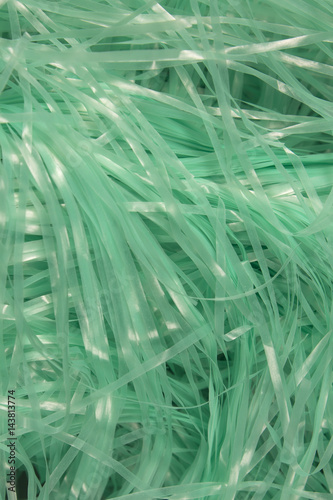 This is a photograph of Turquoise shredded plastic fake Easter grass background