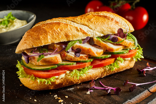 Sliced chicken breast and salad baguette photo