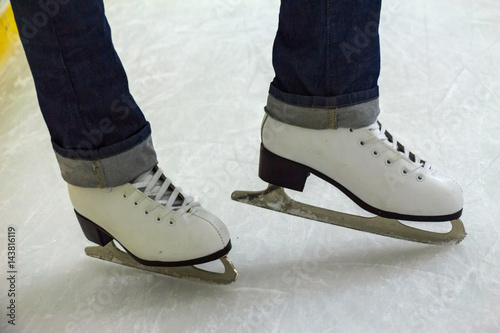 Close up female feet in skates on ice