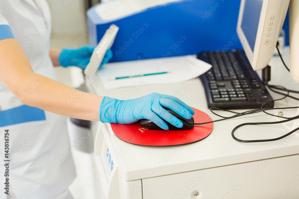Scientist entering data of blood sample in computer at laboratory Scientist entering data of blood sample in computer at laboratory
