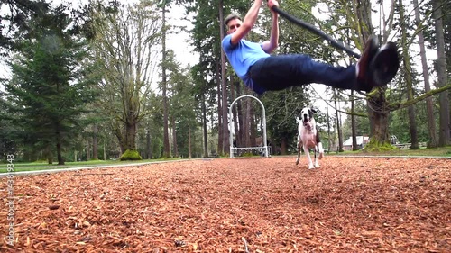 Fast motion man playing with dog in park with zip line