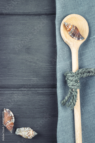 Marine background. Wood made spoon, napkin, seashells. Place for text. Top view with copy space