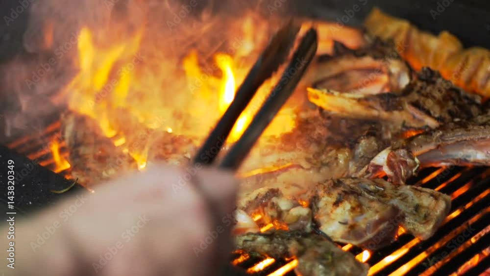 The cook prepares lamb meat on the grill, in slow motion The cook prepares lamb meat on the grill, in slow motion