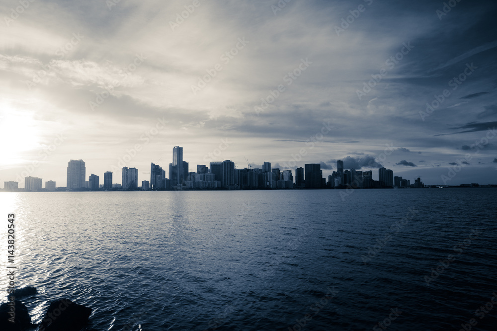 View of Miami Downtown and Brickell at night time during sunset from the bridge with a view on a bay and port, Florida. USA