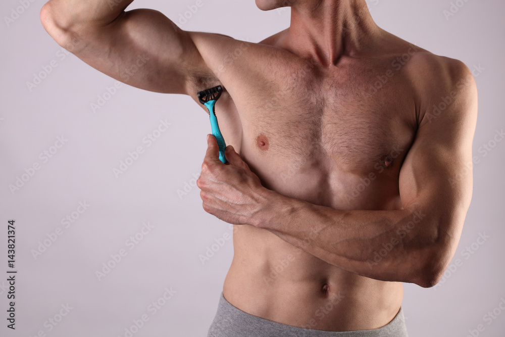 Muscular male torso close up , chest and armpit , underarm hair removal.  Male depilation. Young attractive muscular man using razor to remove hair  from his body Stock Photo | Adobe Stock