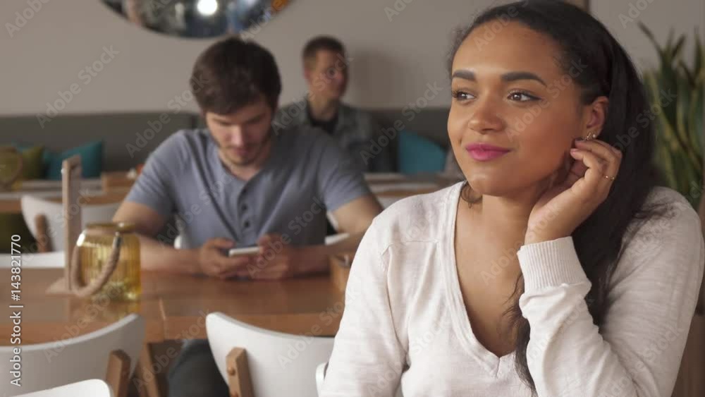 Attractive brown haired girl enjoying the coffee drinking at the cafe. Close up of pretty african american lady slightly smiling at the table. Cute young woman looking at copy place against backgound