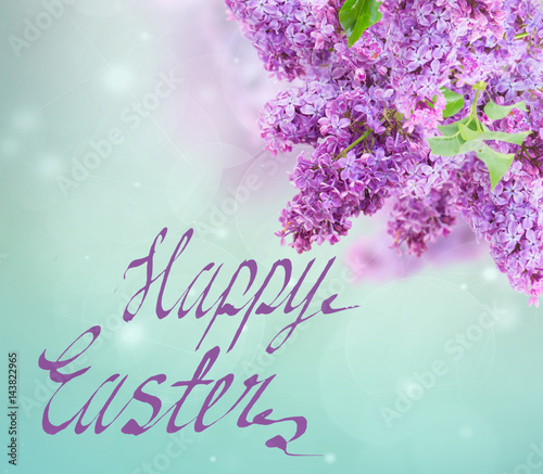 Bush of of purple Lilac flowers on blue sky bokeh background with happy easter greetings
