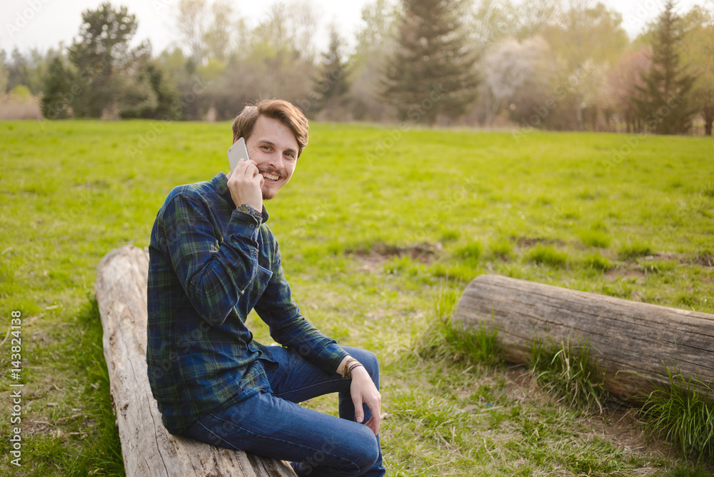 .Handsome guy talking on the phone in the park .Handsome guy talking on the phone in the park
