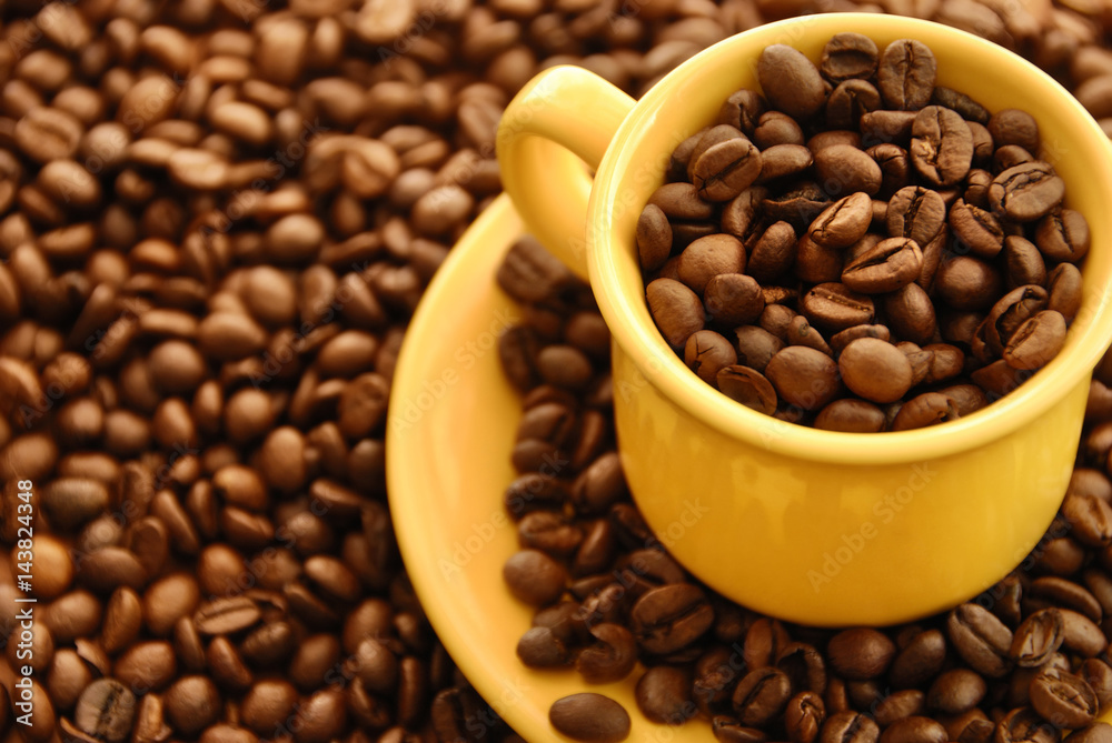 coffee beans in yellow cafe cup and background with coffee beans coffee beans in yellow cafe cup and background with coffee beans