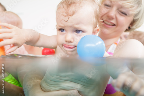 Mums and babies having fun at infant swimming course photo