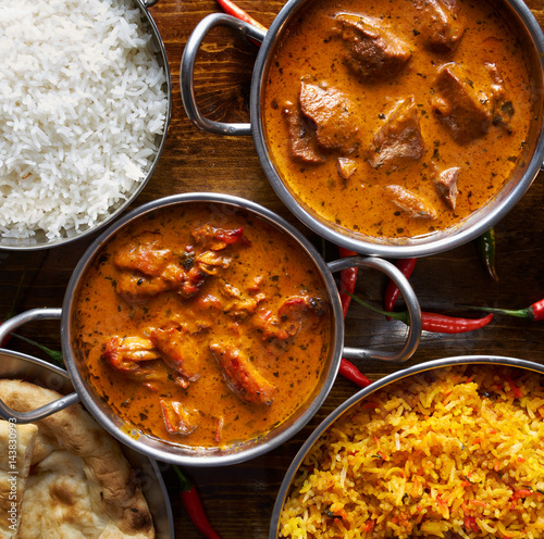assortment of indian curry and rice dishes shot from overhead composition