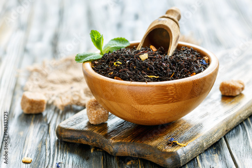 Black tea with bergamot in a bowl and cane sugar. photo