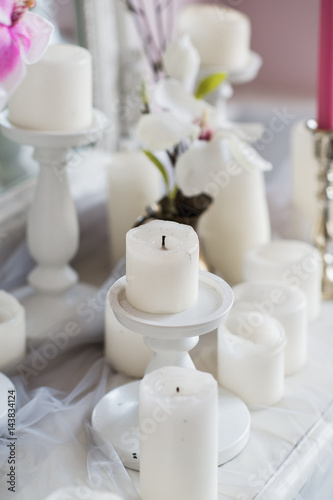 Interior design of white room with beautiful flowers on the served table. Big creative classical mirror at the background.