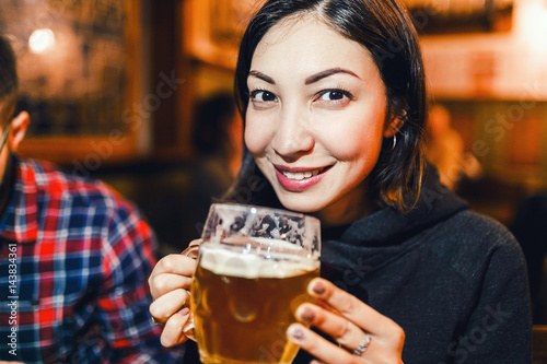 Asian woman drinking beer in a traditional Czech beer house in Prague photo