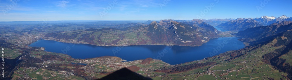 Lake Thunersee and mount Niederhorn. Shadow of mount Niesen. Thun. Village Spiez and others. Panoramic view from mount Niesen.