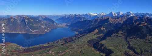 Beautiful autumn day in the Bernese Oberland. Villages Aeschi and Aeschiried. Lake Thunersee. Distant view of Eiger, Monch and Jungfrau.