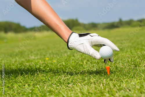 Golf player placing the ball on a tee