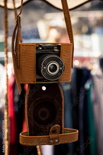A retro camera with a light leater case hanging. photo