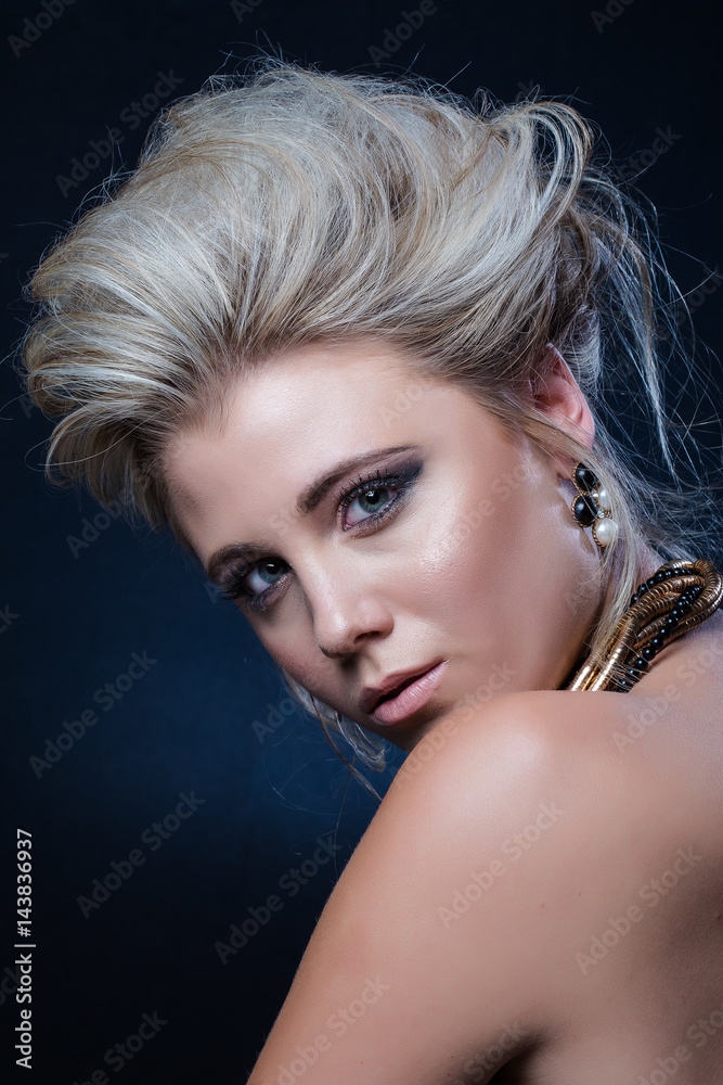Naklejka premium Beautiful blond female fashion model photographed in a dark studio