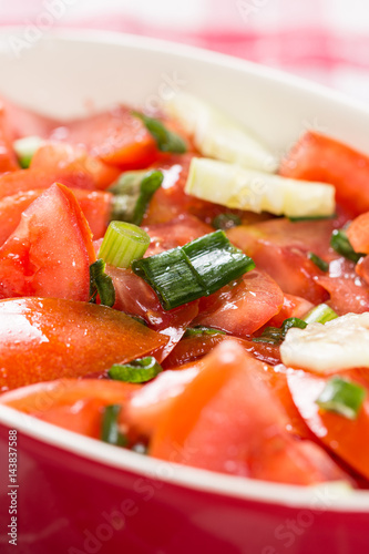 Closeup macro sliced tomato and onions salad on the table