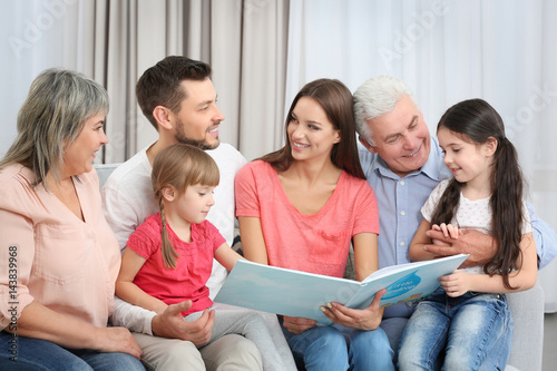 Happy family with book sitt...