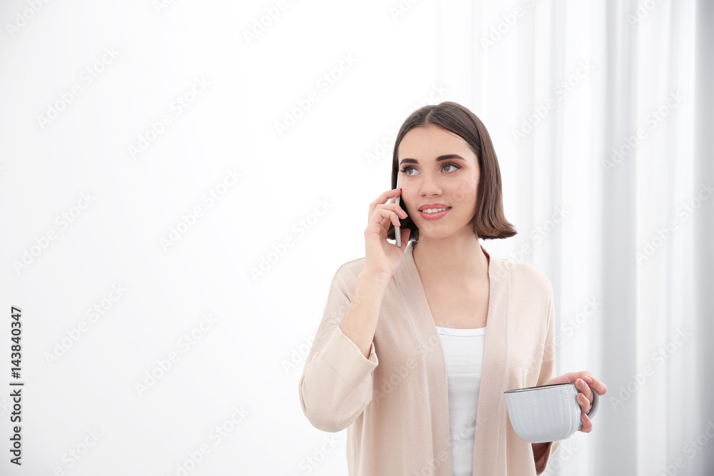 Beautiful young woman talking by mobile phone indoors Beautiful young woman talking by mobile phone indoors