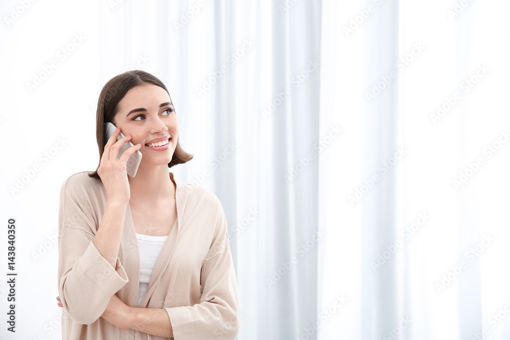 Beautiful young woman talking by mobile phone indoors Beautiful young woman talking by mobile phone indoors