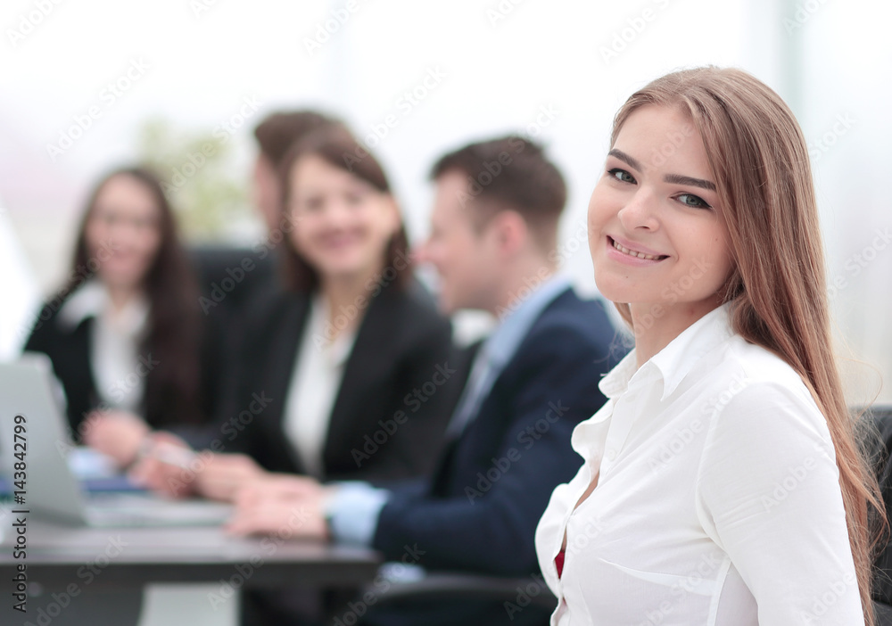 Portrait of a smiling businesswoman sitting at a table with coll Portrait of a smiling businesswoman sitting at a table with coll