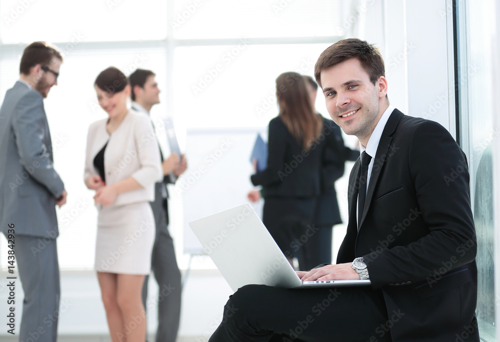 Portrait of a smiling business man sittingwith colleagues workin Portrait of a smiling business man sittingwith colleagues workin
