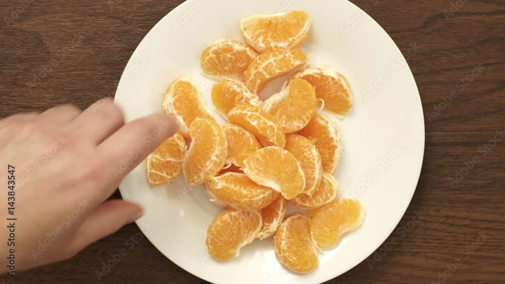 Overhead closeup shot of a couple eating a healthy vegan and all natural snack of the citrus fruit mandarin orange which is sometimes called simply the mandarin or mandarine. Overhead closeup shot of a couple eating a healthy vegan and all natural snack of the citrus fruit mandarin orange which is sometimes called simply the mandarin or mandarine.