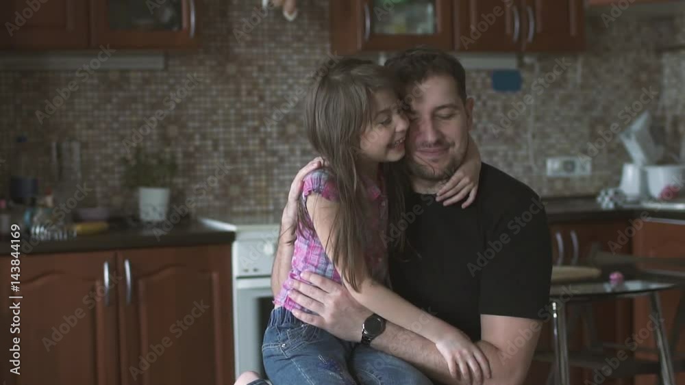 Dad and little daughter hold each other tightly. Little girl kisses her father on the cheek. slow motion Dad and little daughter hold each other tightly. Little girl kisses her father on the cheek. slow motion