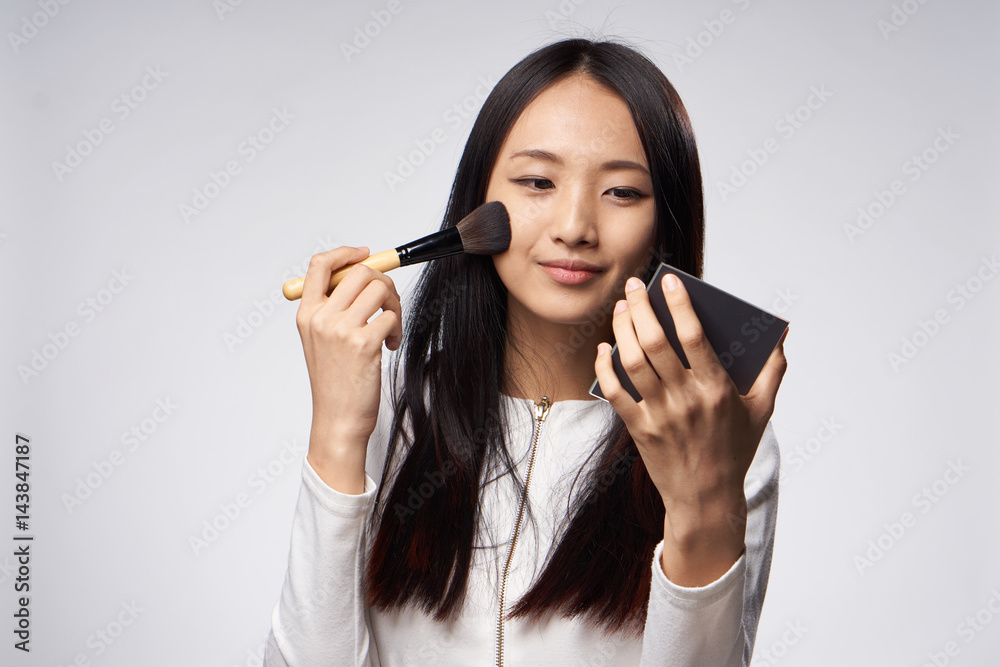 woman doing make-up, wide brush and mirror in hand woman doing make-up, wide brush and mirror in hand